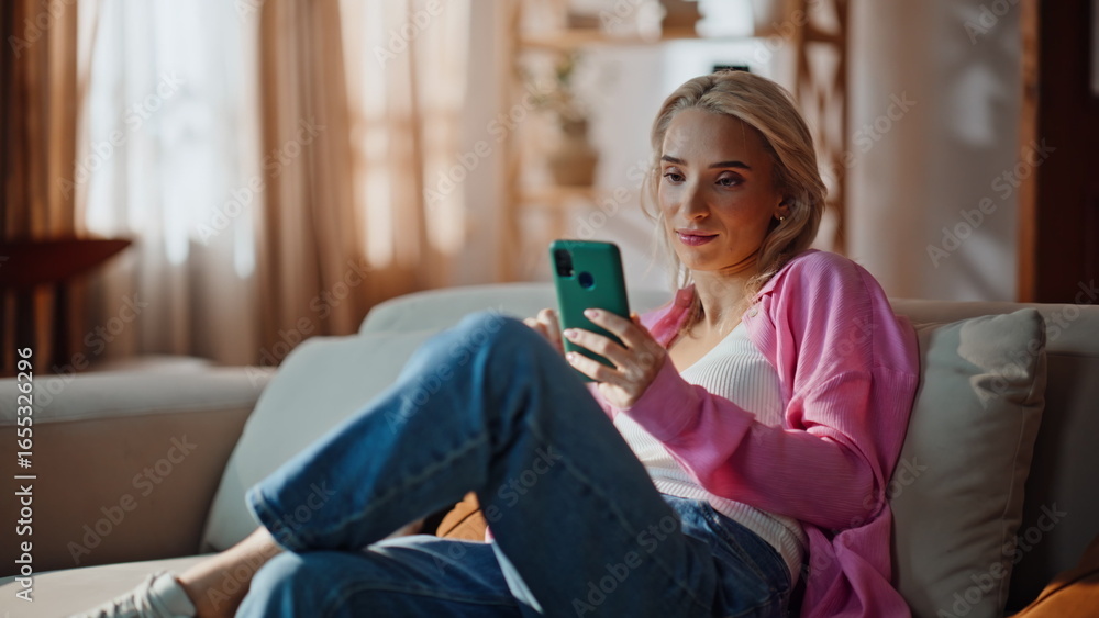 Obraz premium Relaxed girl reading message cellphone at modern apartment closeup. Dreamy woman