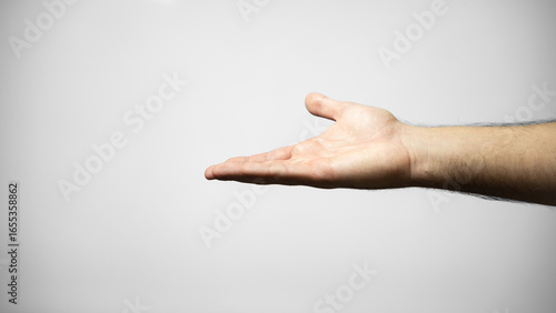Canvas-taulu A man's arm extending his hand with his palm facing up on a plain, isolated white background