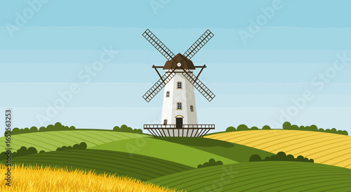 A windmill stands in a countryside against a light blue sky surrounded by green  yellow fields and shrubs