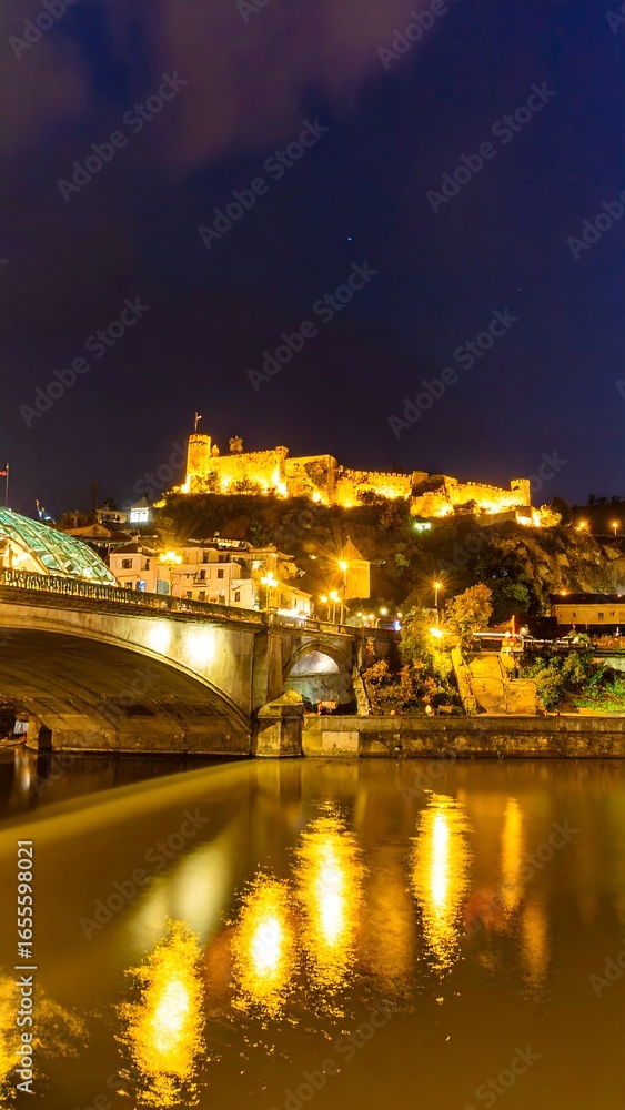 Fototapeta premium Night cityscape with bridge and castle reflection