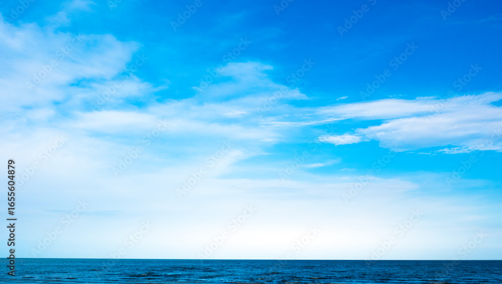 Fototapeta premium Nature of the ocean and blue sky Summer with sunshine, sandy beaches, clear blue waters sparkling against the blue sky. on an island with good ecology and environment Background for summer vacation 