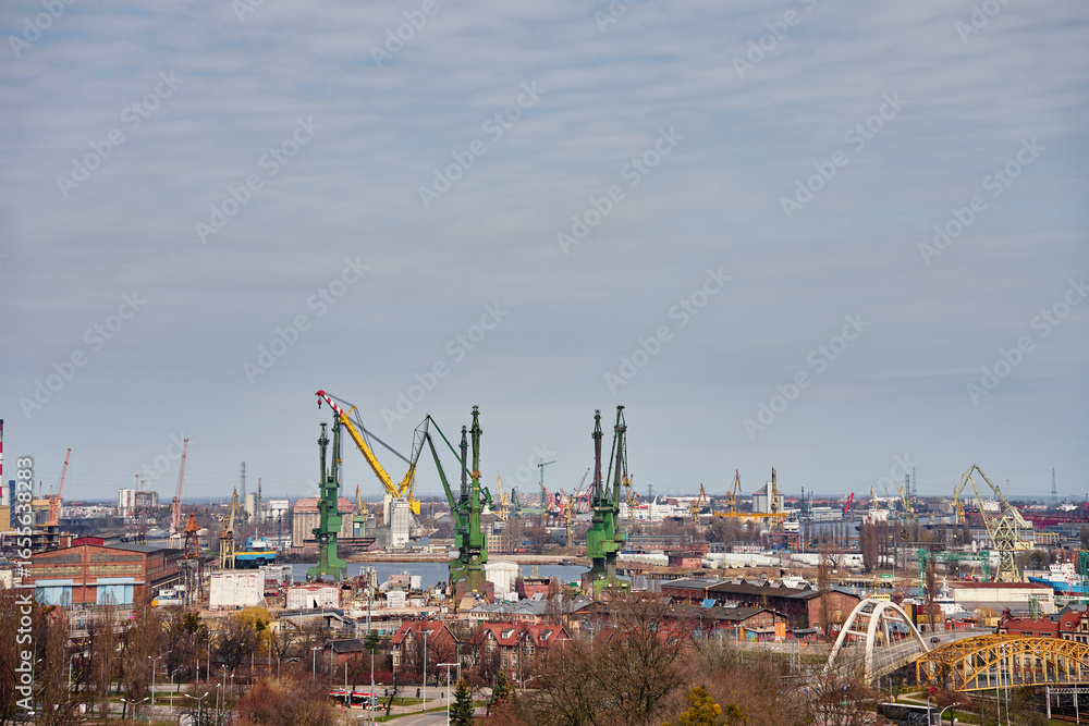 Fototapeta premium Panoramic view of shipyard with port cranes, industrial buildings and harbor infrastructure