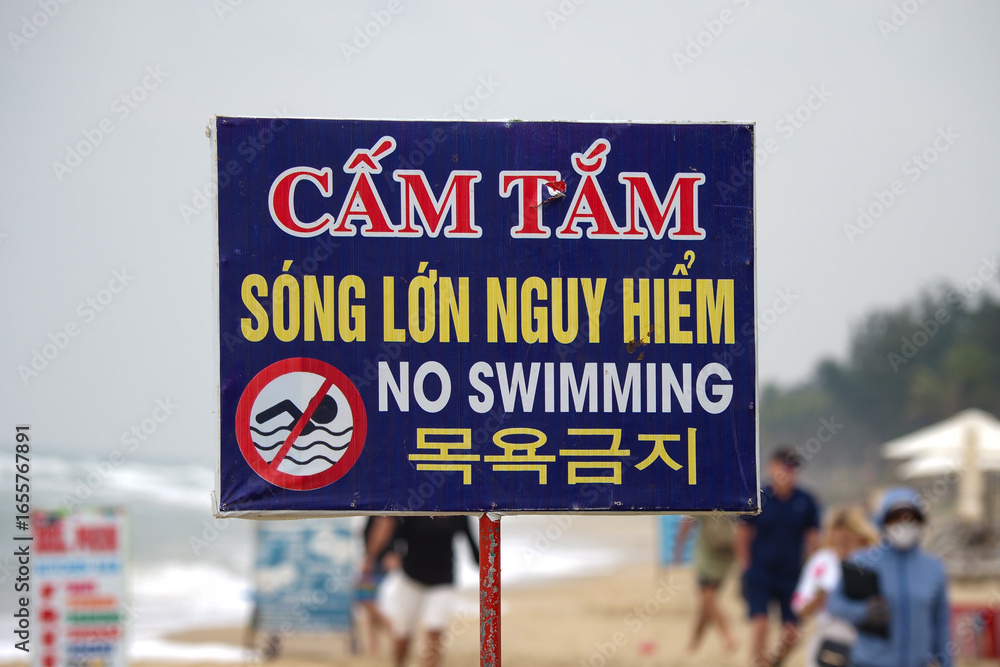 Fototapeta premium No swimming sign due to high waves, seen at Hoi An beach, Da Nang, Vietnam