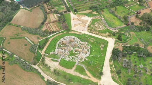 Drone shot of Ggantija Archaeological Park in Gozo with ancient stone temple ruins on green land