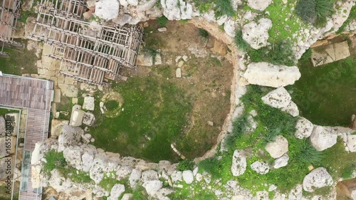 Drone shot of Ggantija Archaeological Park in Gozo with ancient stone temple ruins on green land