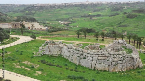 Drone shot of Ggantija Archaeological Park in Gozo with ancient stone temple ruins on green land