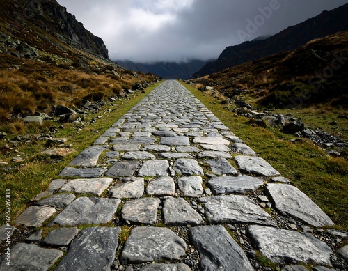 Stone path receding into a mountain pass under a cloudy sky