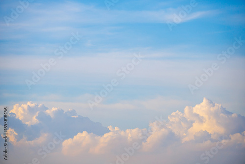 Fluffy cumulus clouds rise majestically along the horizon sky