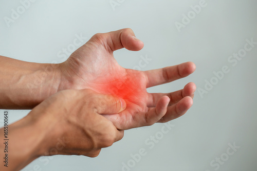 Obraz na płótnie Close-up of a hand with red highlighted pain in the palm, symbolizing arthritis, tendonitis, carpal tunnel, or work injury from office syndrome, useful for medical, therapy, and healthcare design