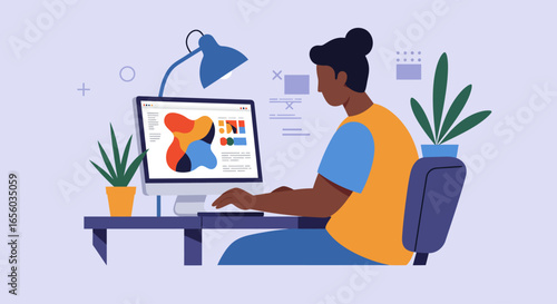 A Black female graphic designer working on a creative project on her computer at a modern desk.