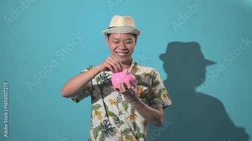 An Asian person saving money in a piggy bank and exchanging with a suitcase, filmed against a simple background, symbolizing finance, savings, travel, and lifestyle concepts