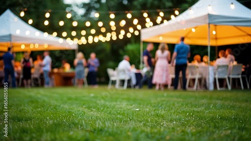 Outdoor event with tents and string lights. People socialize on a grassy area. Evening atmosphere with warm lighting.