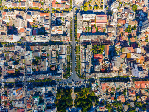 Wallpaper Mural Flat aerial view of Durrës, Albania, showing residential streets, houses, and roads. The scene captures a mix of modern and older buildings, blue rooftops, and the urban layout under a sunny sky. Torontodigital.ca