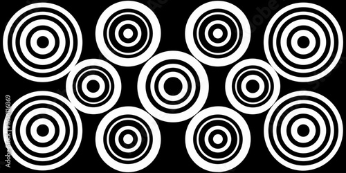 A collection of twelve circular graphic elements, set against a black background. Each element is composed of radiating, concentric, thin, white lines forming various circular and spiral patterns. Som