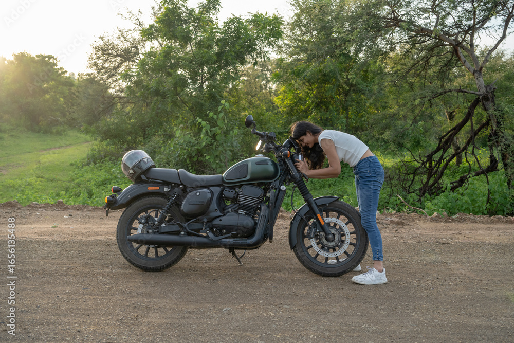 Obraz premium Strong independent Indian woman biker: beautiful girl, stylish rider, motorcycle adventure, elegant jacket, confident posture, powerful machine, free spirit, road journey, fearless attitude.