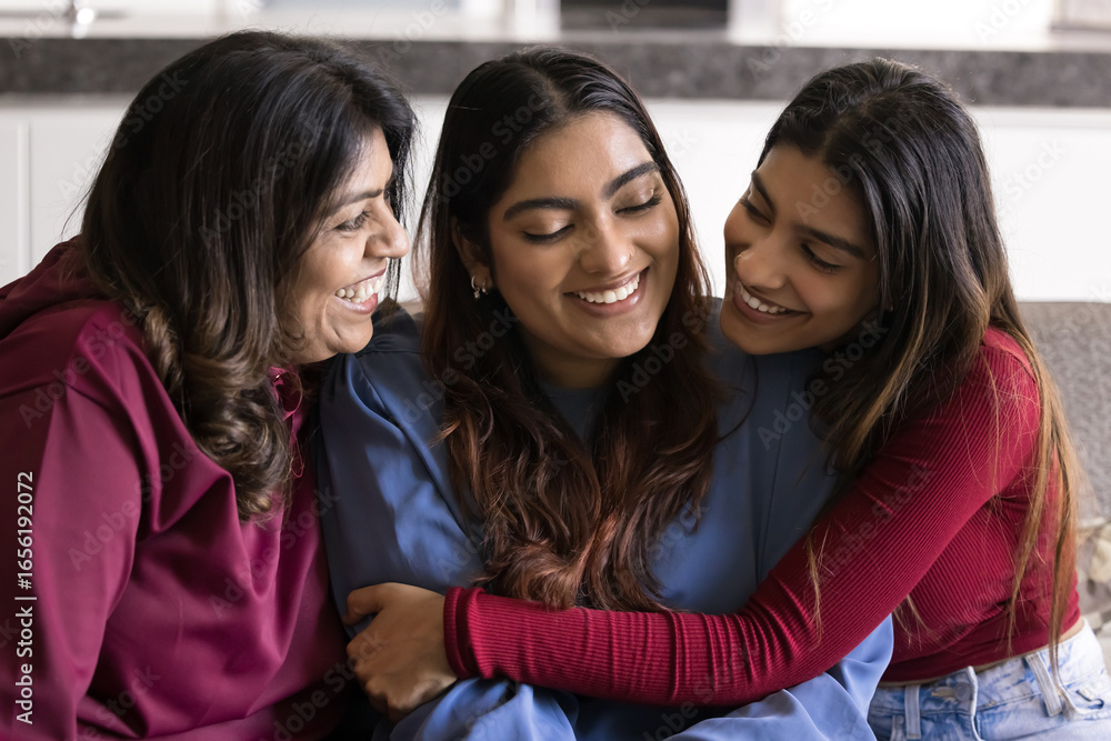 Obraz premium Family bonding and love. Happy older mom grown sister cuddle smiling young woman sitting on sofa greet on birthday celebrate personal milestone achievement express unity devotion support encouragement