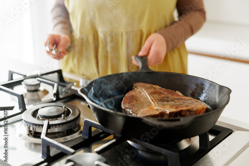 Photography Cooking T-bone steak in cast iron pan