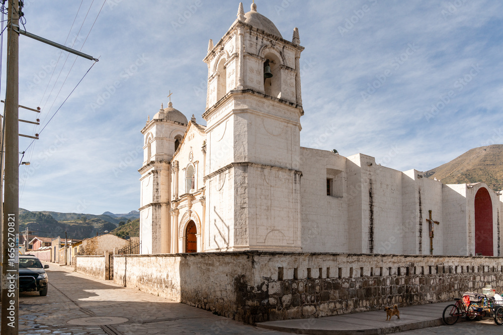 Fototapeta premium Kirche von Sibayo im Colca-Tal, Peru unter blauem Himmel mit weißen Wolken, traditionelle Architektur, historisches Gebäude, Andenlandschaft