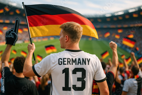 German supporter raising flag at soccer stadium celebration