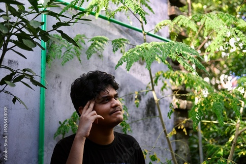 portrait of a young depressed man in a garden