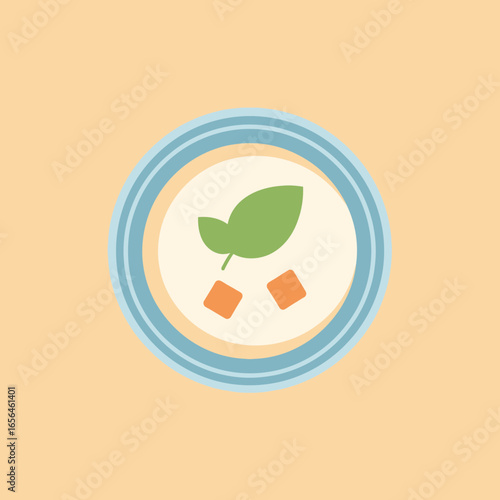 Bowl of creamy soup with greens and croutons.