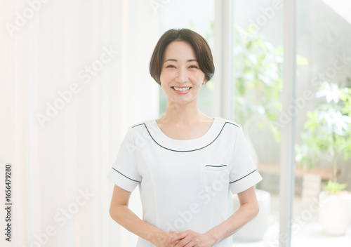 エステティシャン/セラピスト。彼女は手を前で組みカメラ目線で微笑んでいる。 Free Download エステティシャン/セラピスト。彼女は手を前で組みカメラ目線で微笑んでいる。 - GFXLoad