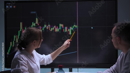 Wallpaper Mural Woman and man at table in high-tech office analyzing stock market charts on screen Torontodigital.ca