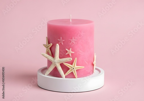 A burning Christmas candle decorated with stars sits on a white stand, casting a soft, romantic light