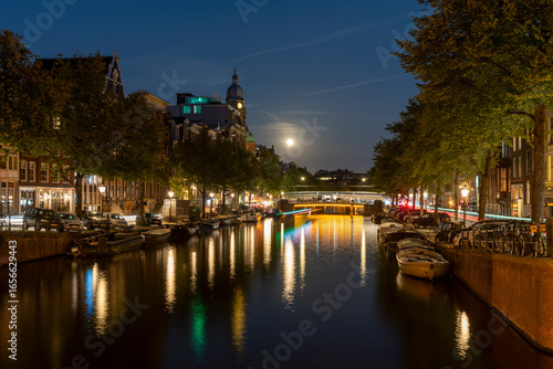 Amsterdam by night in the Netherlands, with canals, lights, reflections int the water