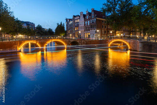 Amsterdam by night in the Netherlands, with canals, lights, reflections int the water