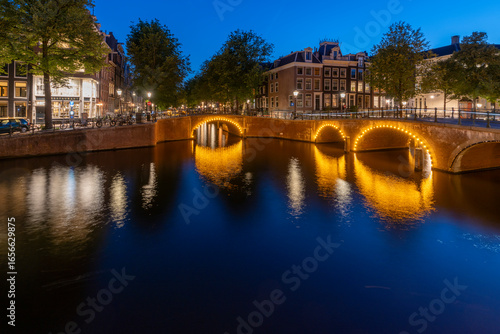 Amsterdam by night in the Netherlands, with canals, lights, reflections int the water