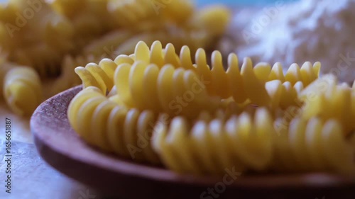 Slow motion pan of dried fusilli pasta and flour