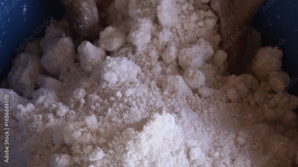 Revirando massa de tapioca em casa de farinha, mãos feminina preparando a tapioca tradicional do nordeste, goma de mandioca com coco ralado, misturando fécula