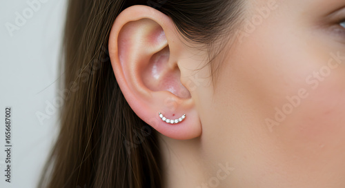A close-up shot of an earlobe adorned with a simple, elegant earring.