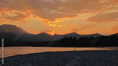 Sunset time lapse. Stunning sunset over mountains and river creating a serene evening atmosphere in a natural landscape