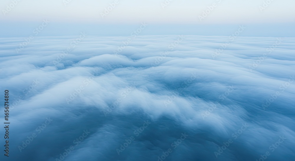 Obraz premium Ethereal Blue Cloudscape: Aerial View of Dense, Dreamy Clouds at Dawn