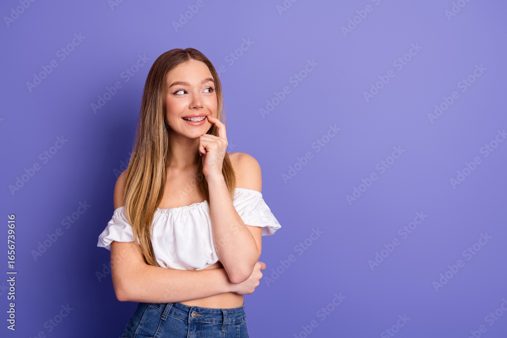 Charming young woman in casual white top and denim posing thoughtfully against a vibrant purple background Charming young woman in casual white top and denim posing thoughtfully against a vibrant purple background