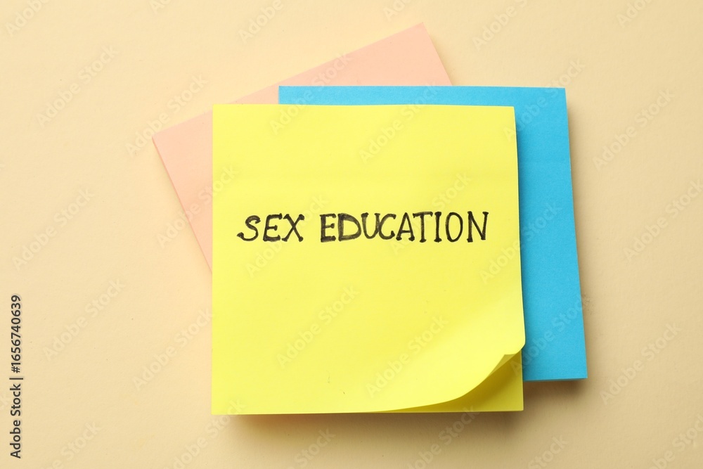 Sticky notes with words Sex Education on beige background, top view Sticky notes with words Sex Education on beige background, top view