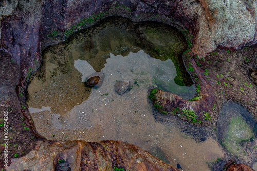 top view of small lake with calm, clean and clear water at edge of a mountain