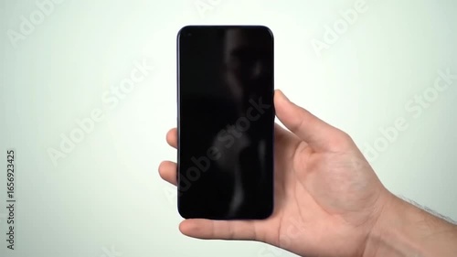 Hand holding smartphone on white background.