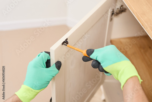 Woodworking professional fastening door hinge screws, precise carpentry skills during home improvement project
