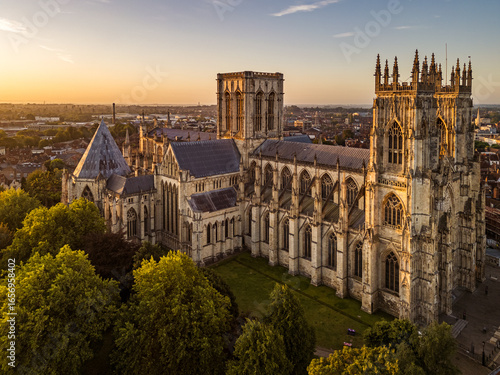 Aerial view of York Minster in York, North Yorkshire, UK, at sunrise, showing the medieval cathedral’s intricate Gothic architecture and surrounding historic cityscape on a summer morning August 2025.