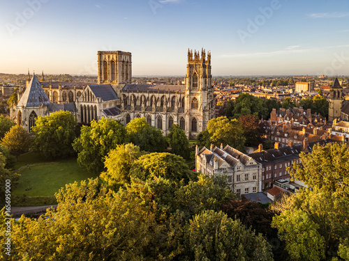 Aerial view of York Minster in York, North Yorkshire, UK, at sunrise, showing the medieval cathedral’s intricate Gothic architecture and surrounding historic cityscape on a summer morning August 2025.
