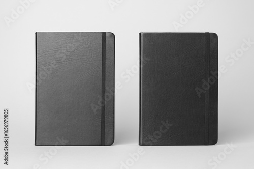 Mockup of two black notebooks on a gray background