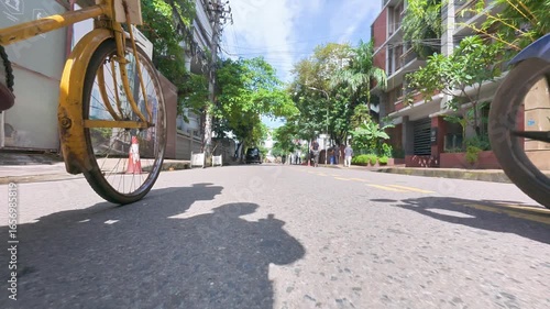 Dhaka, Bangladesh-09-04-2025: Low-Angle Perspective of a Person Cycling Down an Urban Street
