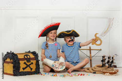 Fotografía Two kids explore pirate adventures with map, sword and chest