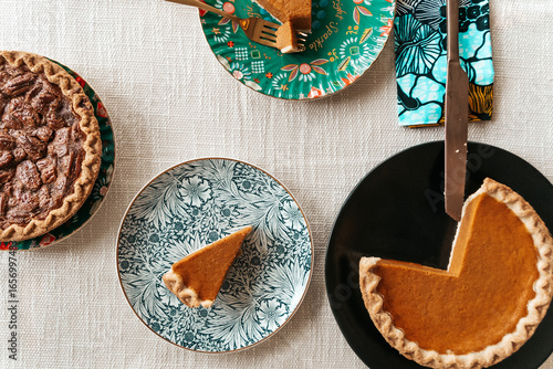 Homemade pecan and pumpkin pie desserts served at holiday dinner table
