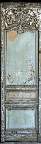 Vintage ornate door with peeling paint, showcasing intricate woodwork and faded elegance.