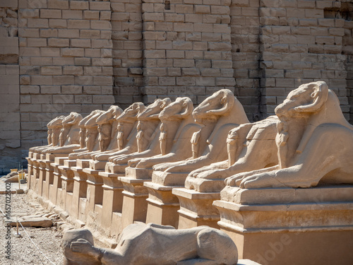 The entrance of Karnak Temple, featuring rows of ram-headed sphinx statues lining the Avenue of Sphinxes, leading to the ancient temple complex