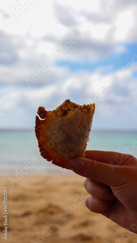 Fototapeta Naklejka Na Ścianę i Meble -  Pastel de carne servido como petisco na praia de Fernando de Noronha, combinando gastronomia local com o cenário paradisíaco e o mar cristalino do arquipélago.